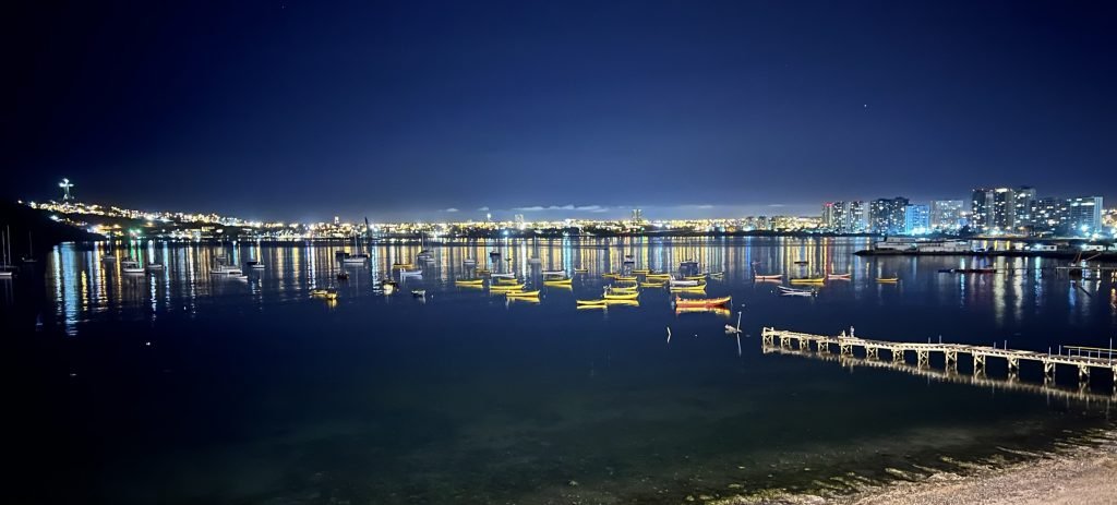 barcos y luces sobre el mar de noche